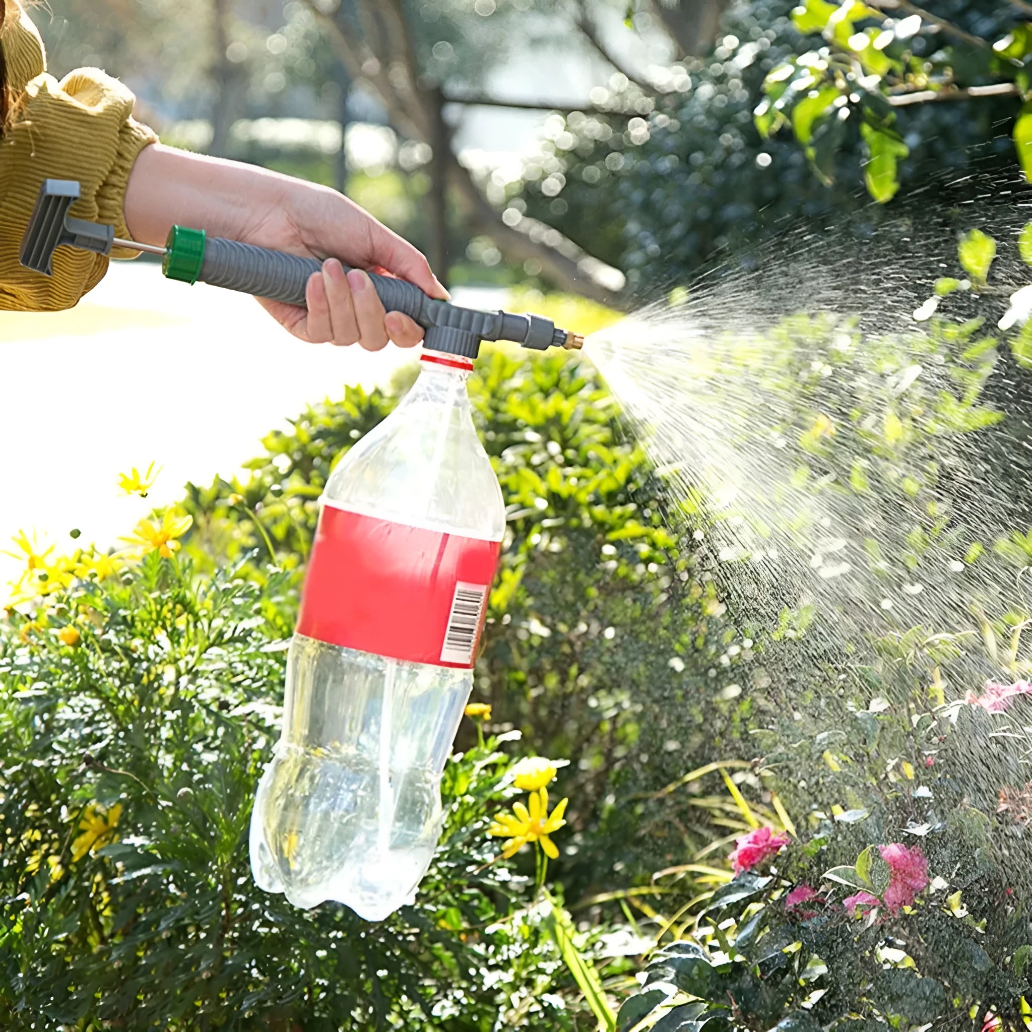Grey watering sprayer nozzle attached to plastic bottle with 30cm connecting tube for garden watering