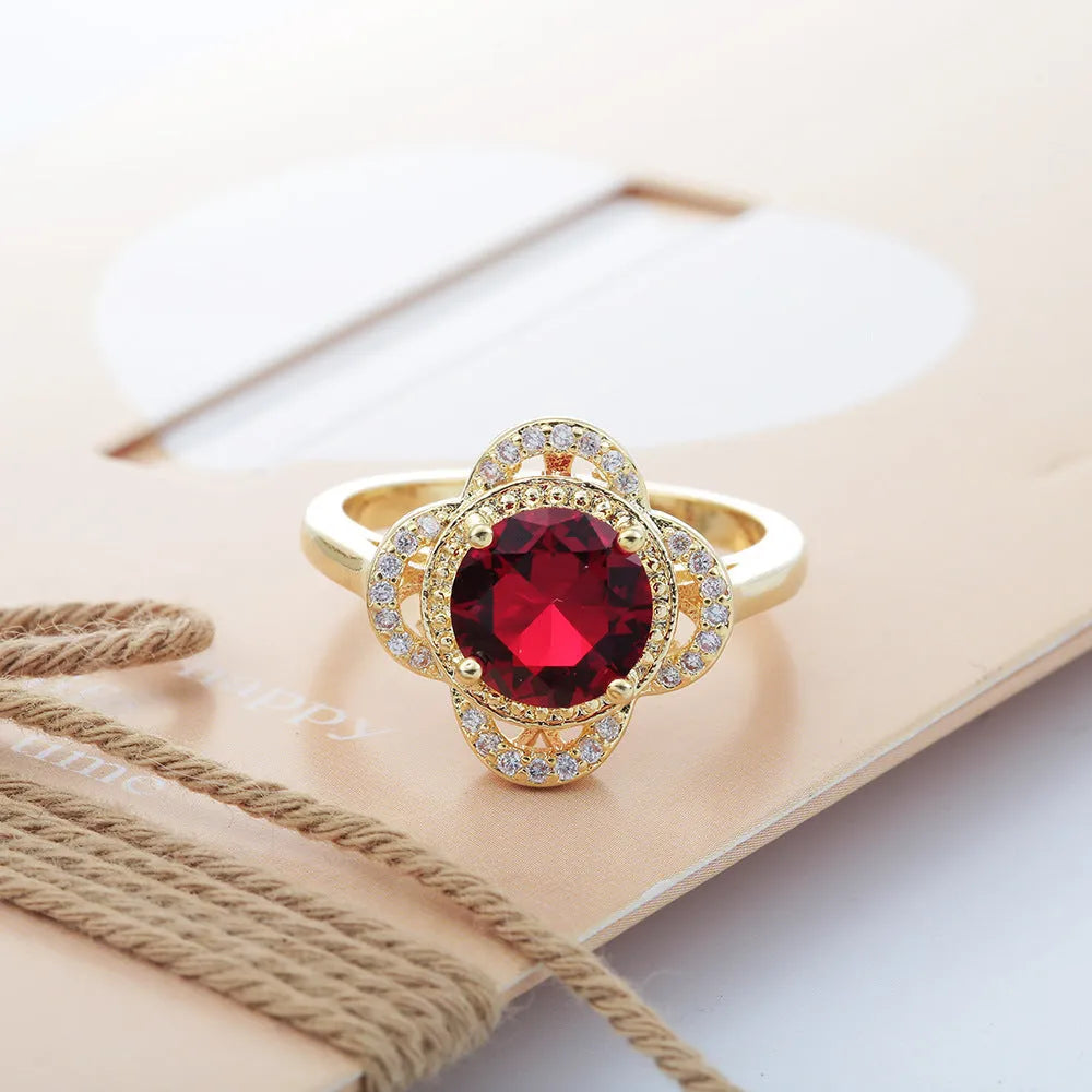 Copper fruit-shaped ring with inlaid zircon stones on a finger.