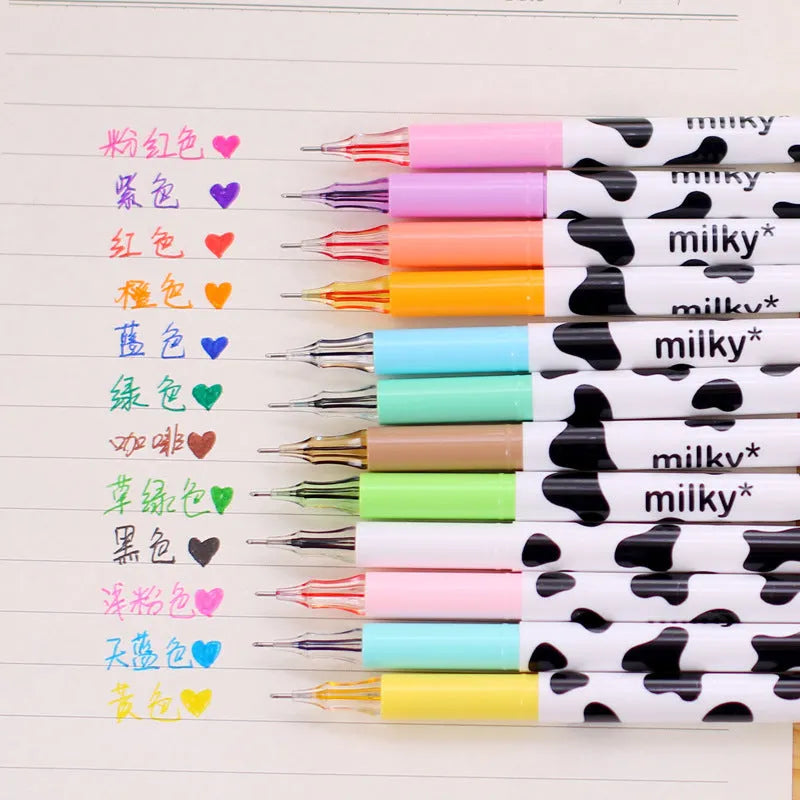 Set of 12 cow print design gel pens with 0.38mm tips in assorted colours laid out next to their box.