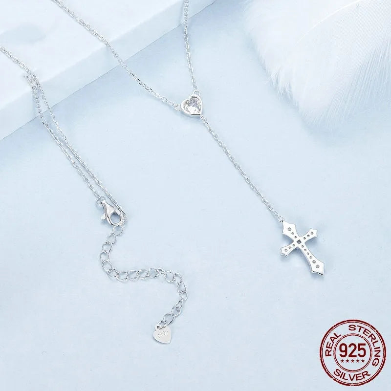 Close-up of a sterling silver V-neck love cross pendant on an O-ring chain.