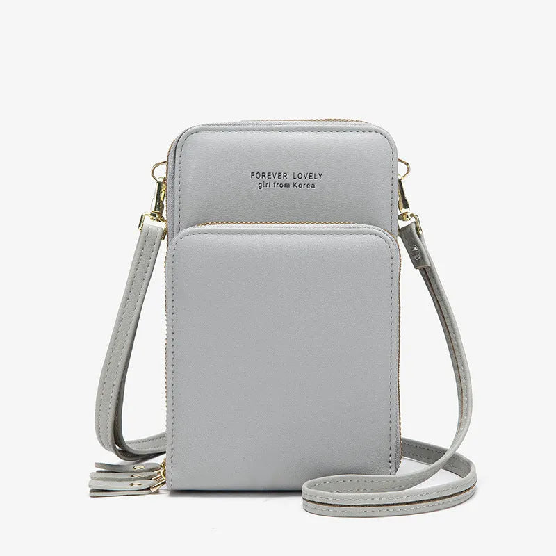 Green crossbody bag with tri-fold pockets and zipper closure on white background