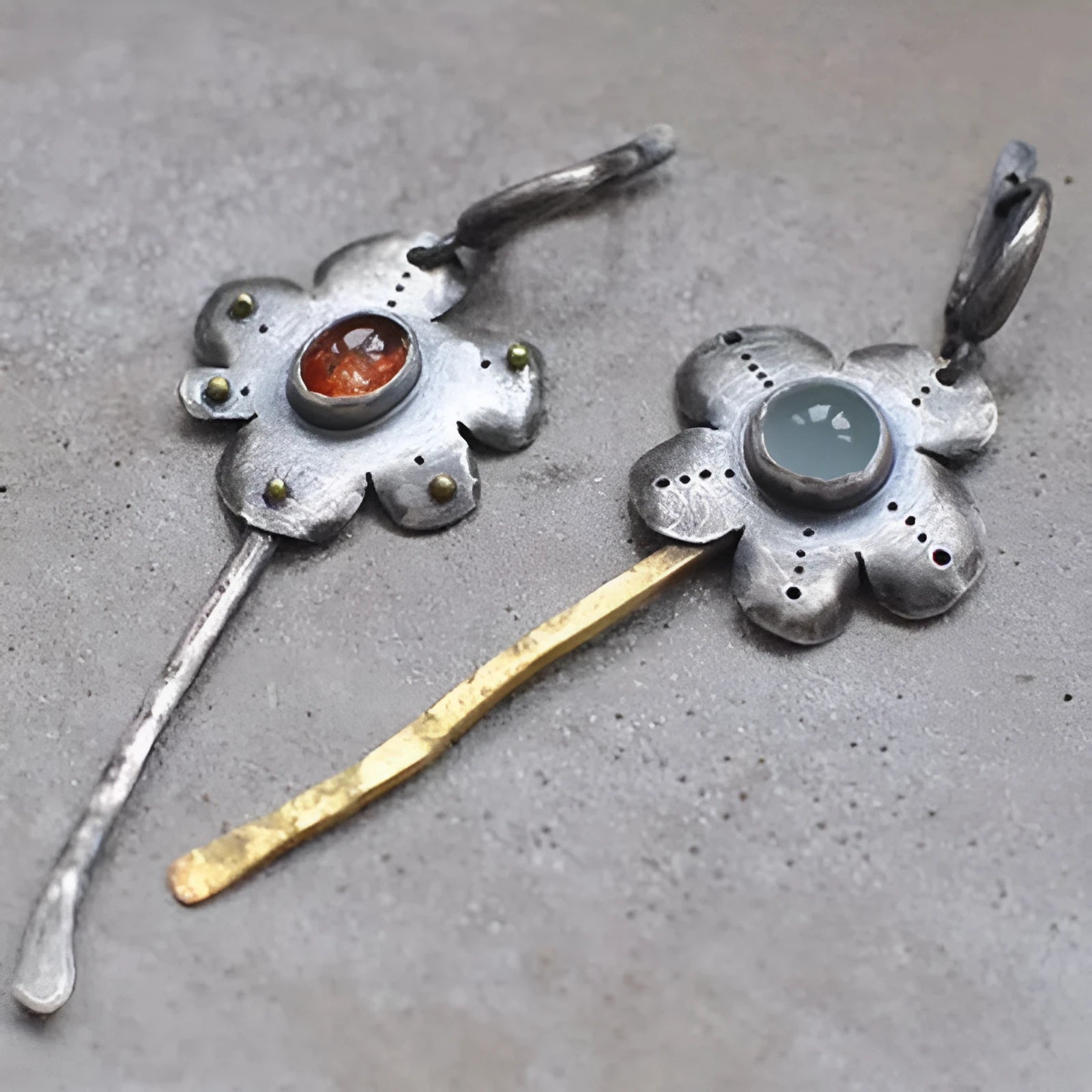 A pair of long, geometric flower-shaped drop earrings with an asymmetric two-tone metallic finish.