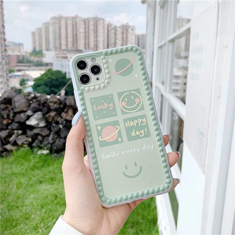 Green TPU iPhone back cover case with geometric smiley face and polka dot frame design.