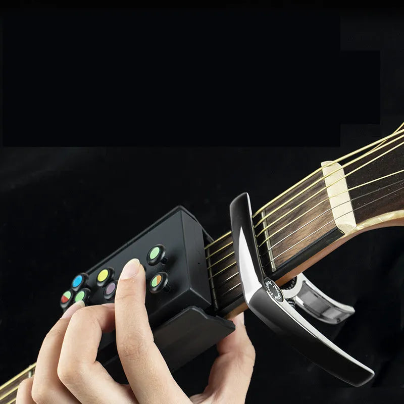 Black guitar finger trainer attached to a folk guitar fretboard
