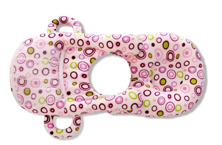 Pink plush baby feeding pillow on a carpet, showing its 30cm by 42cm size and soft texture.