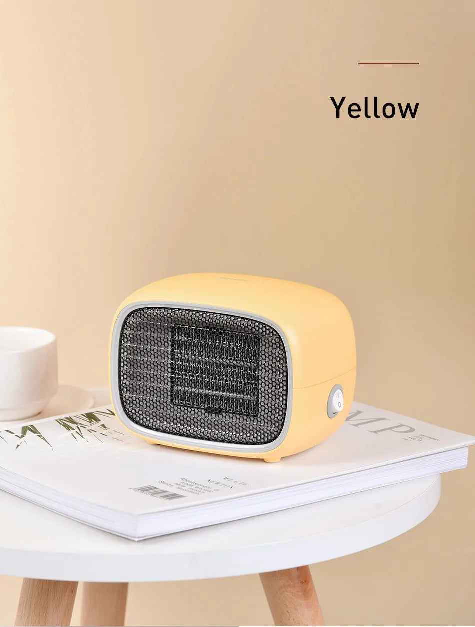 Compact green mini desktop heater with metal grille and EU plug on a wooden desk.