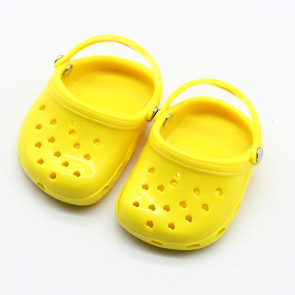 Set of small plastic doll beach slippers in blue, red, yellow, and green colours.