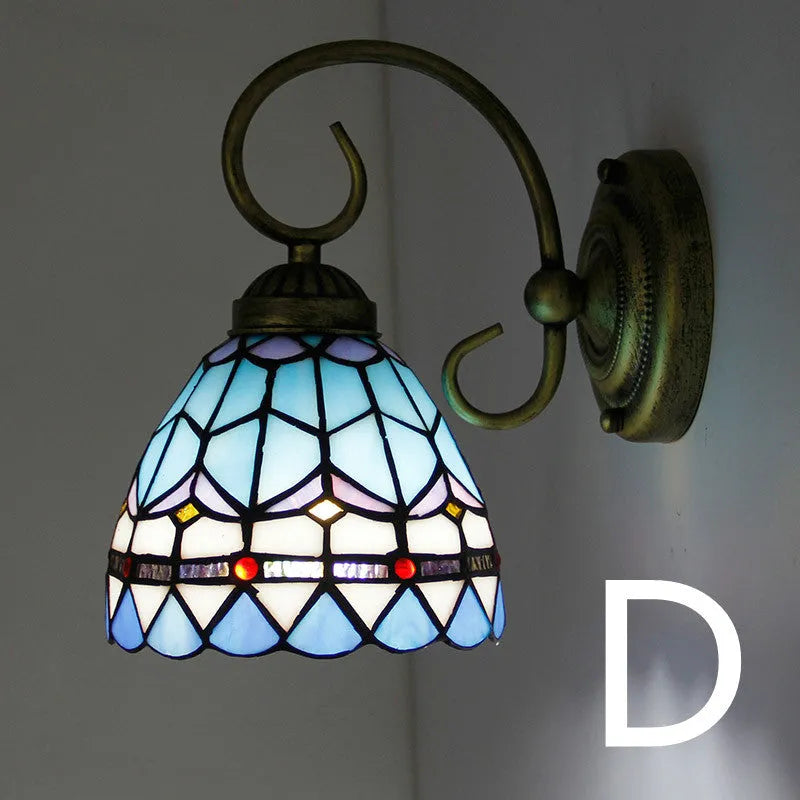 A coloured stained glass wall lamp in a simple contemporary style, mounted on a wall.