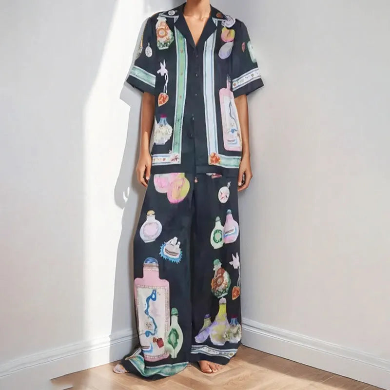 Black women's casual set with cartoon print, featuring a cardigan and matching trousers on a hanger.
