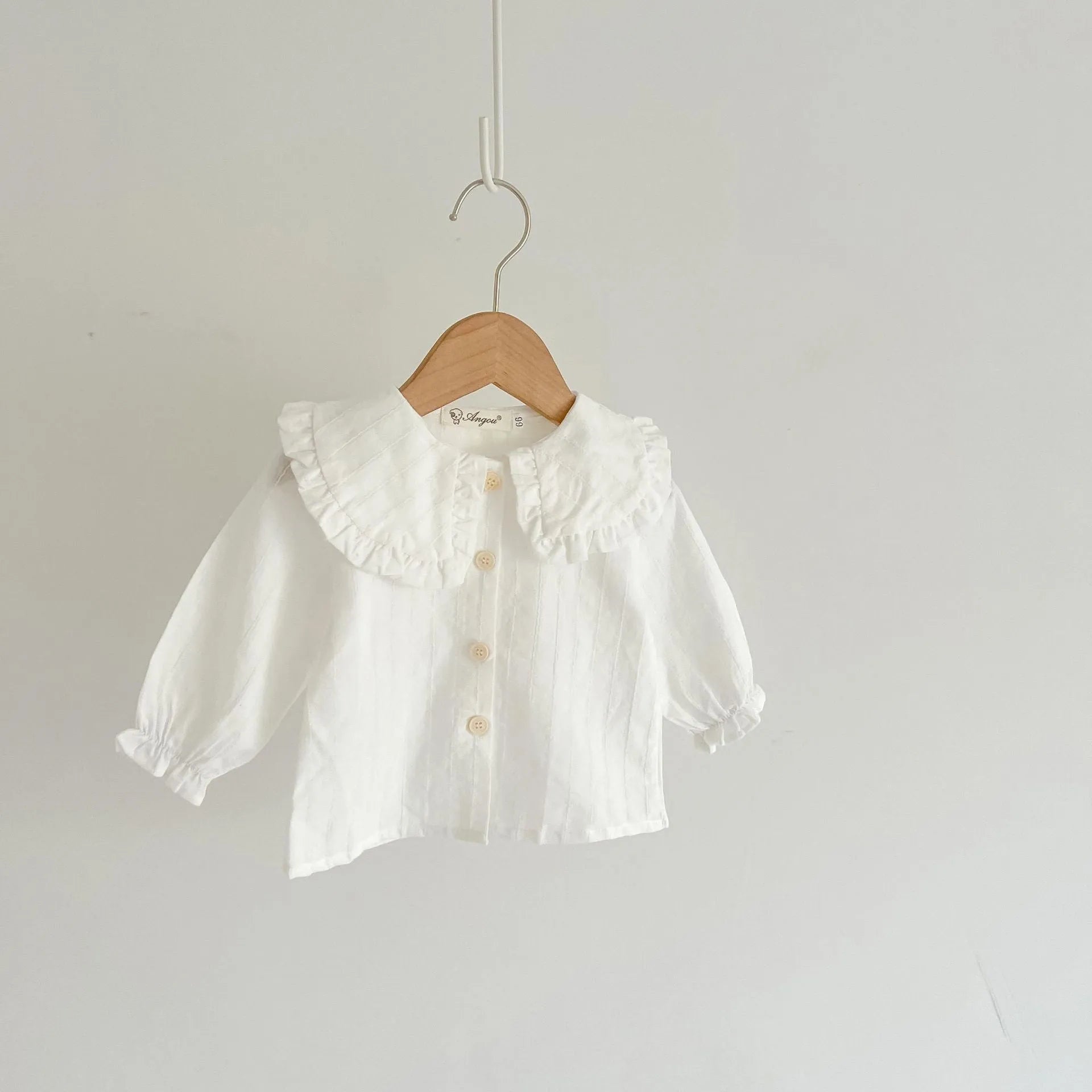 Apricot coloured baby girl's cotton romper with white top, adjustable suspenders, and mid-waist trousers.