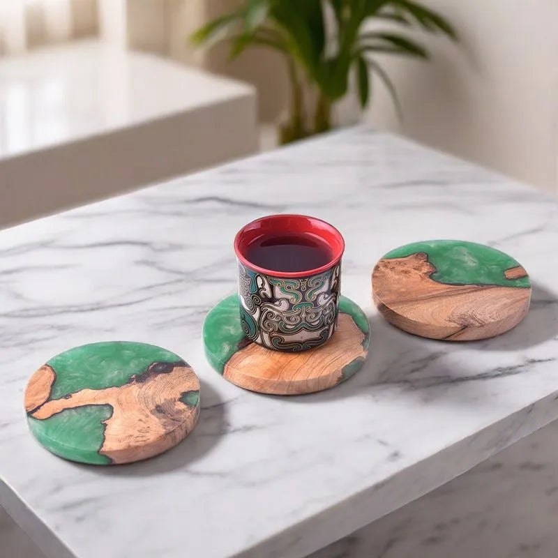 Set of solid colour resin coasters in black and green, showing round and square shapes on a wooden table.