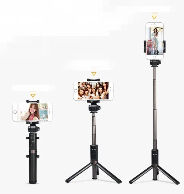 Black Bluetooth selfie stick with tripod base and remote control extended next to smartphone