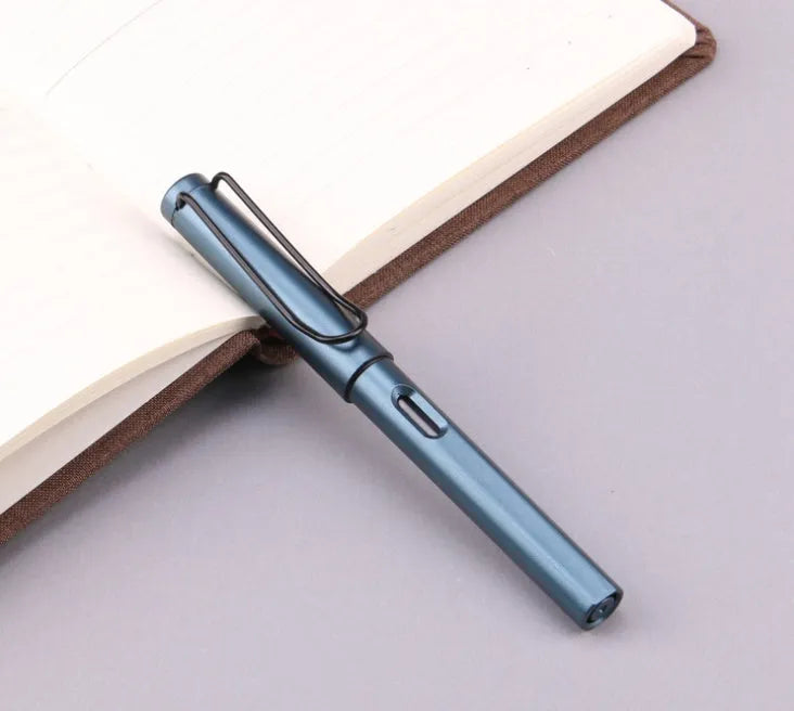 Close-up of a frosted texture fountain pen with a stainless steel nib, shown next to black and blue ink cartridges.