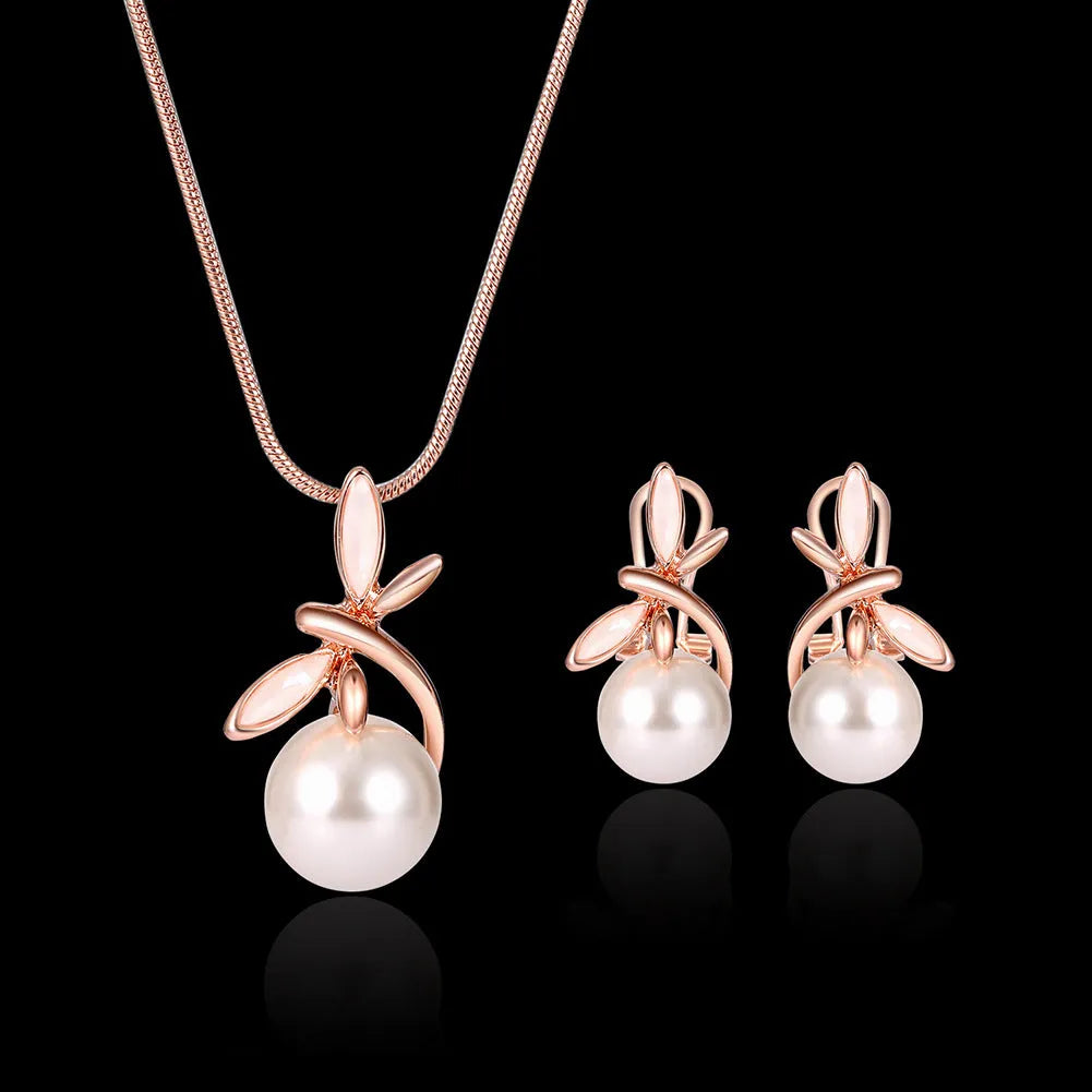 Rose gold alloy necklace with artificial gem pendant and matching earrings on a display surface