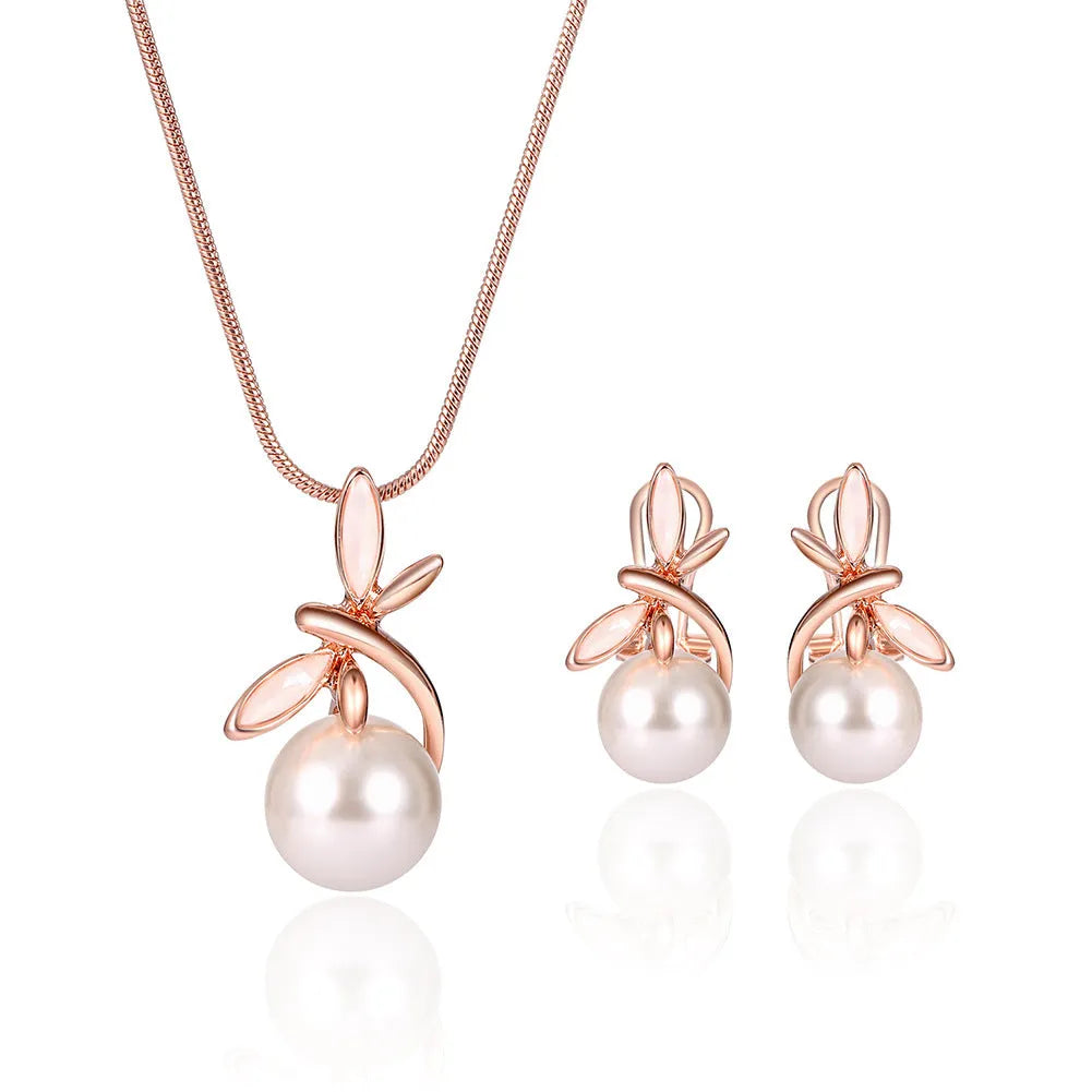 Rose gold alloy necklace with artificial gem pendant and matching earrings on a display surface