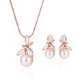 Rose gold alloy necklace with artificial gem pendant and matching earrings on a display surface