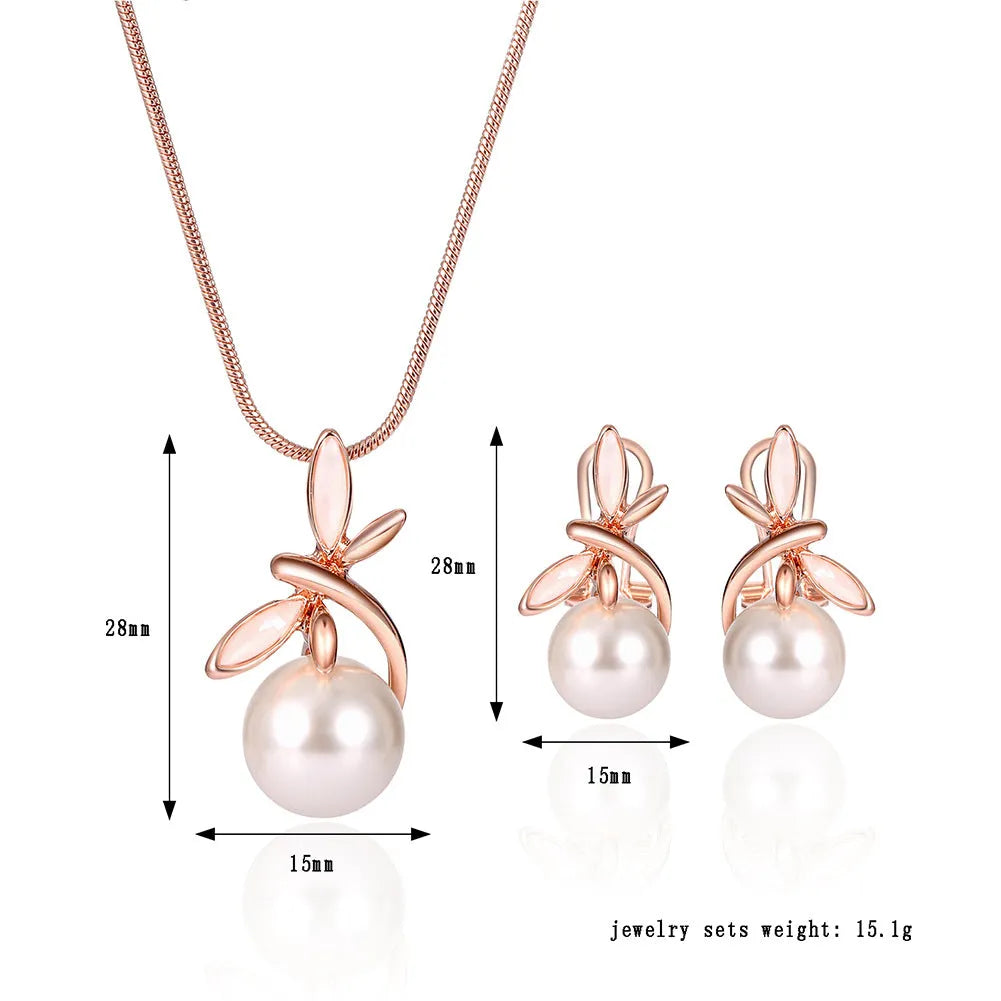 Rose gold alloy necklace with artificial gem pendant and matching earrings on a display surface