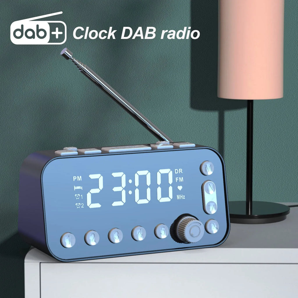 Black DAB bedside alarm clock with large LED display, pig tail antenna, and USB ports on a wooden table.
