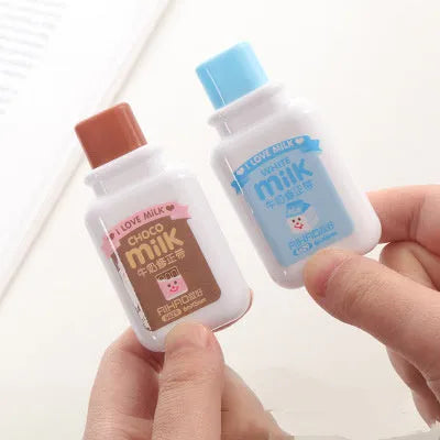 A cute, patterned bottle-shaped correction tape dispenser with a curved design, shown on a paper surface.