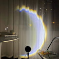 INS USB Moon Lamp LED projector on a table projecting rainbow light onto a wall.