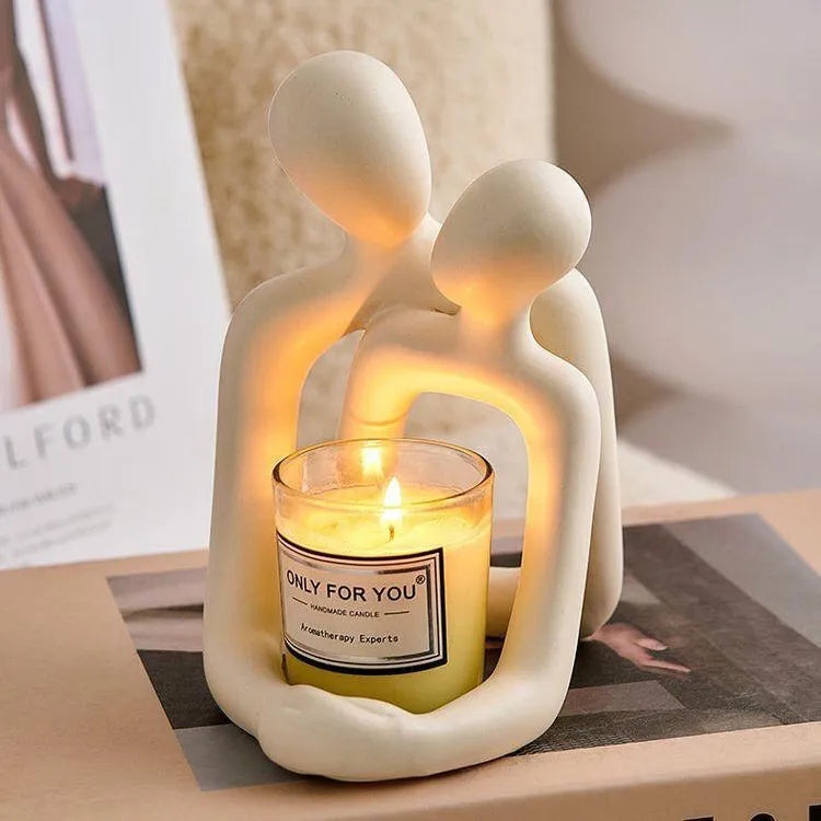 A modern minimalist loving couple resin statue in either milky white or gold finish, displayed on a surface.