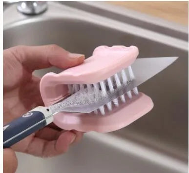 Blue U-shaped plastic brush for cleaning kitchen forks, knives and spoons on a countertop.