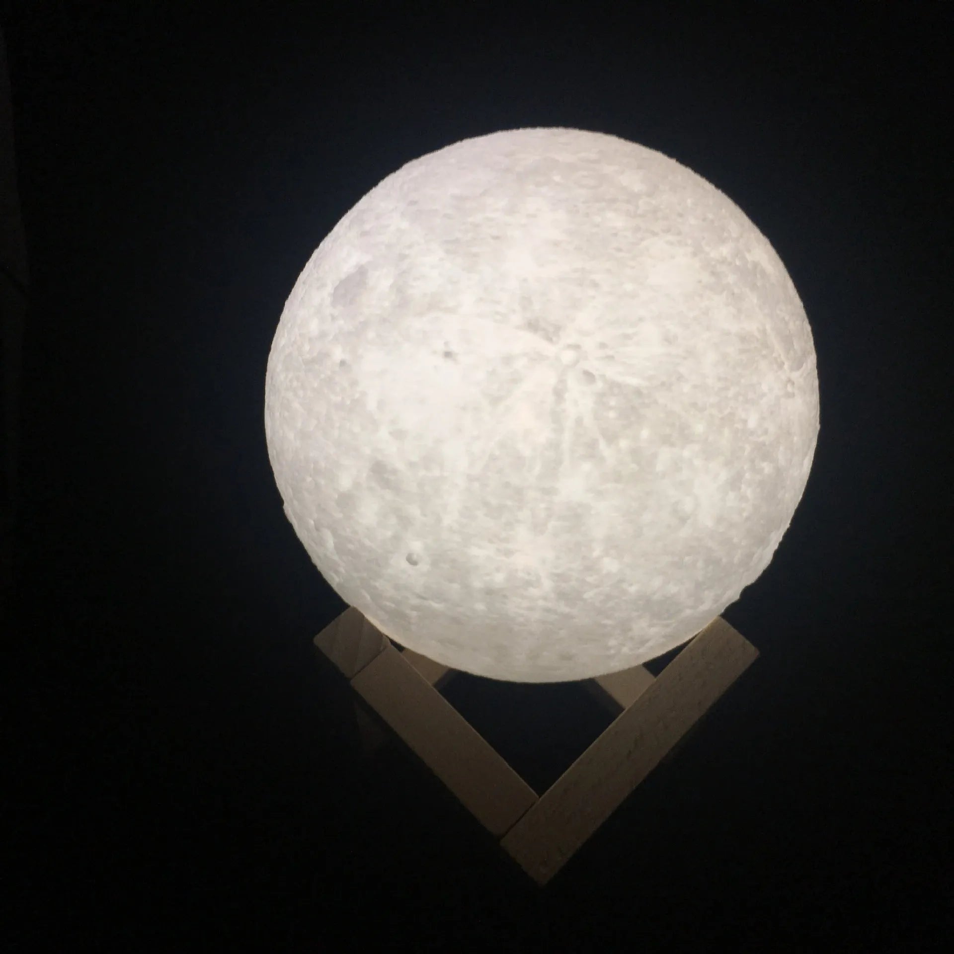 3D printed white moon lamp with textured surface on a wooden stand, showing touch ring at base