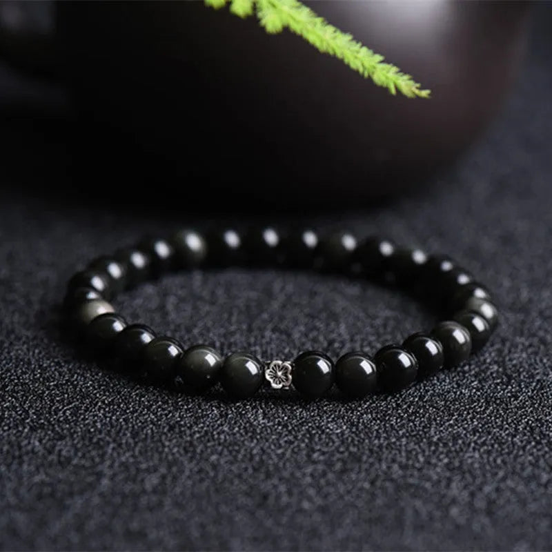 Natural obsidian beaded bracelet with S925 silver flower charms and dragon phoenix constellation design.