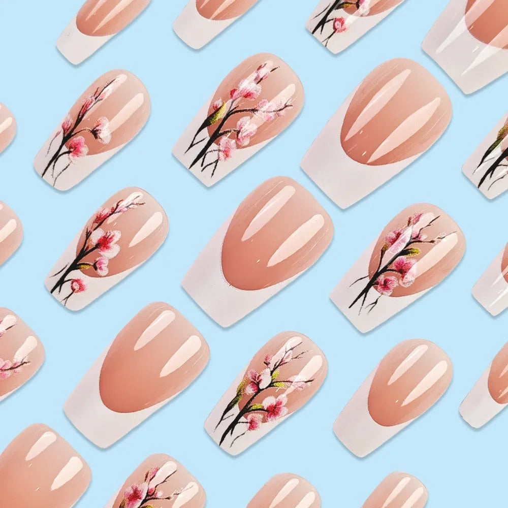 Plum blossom style nail tips with simple white edge French design and starry sky pattern on a table