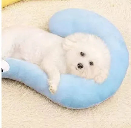 Blue U-shaped cloth pillow for cats on a wooden floor, showing its head-cradling design.
