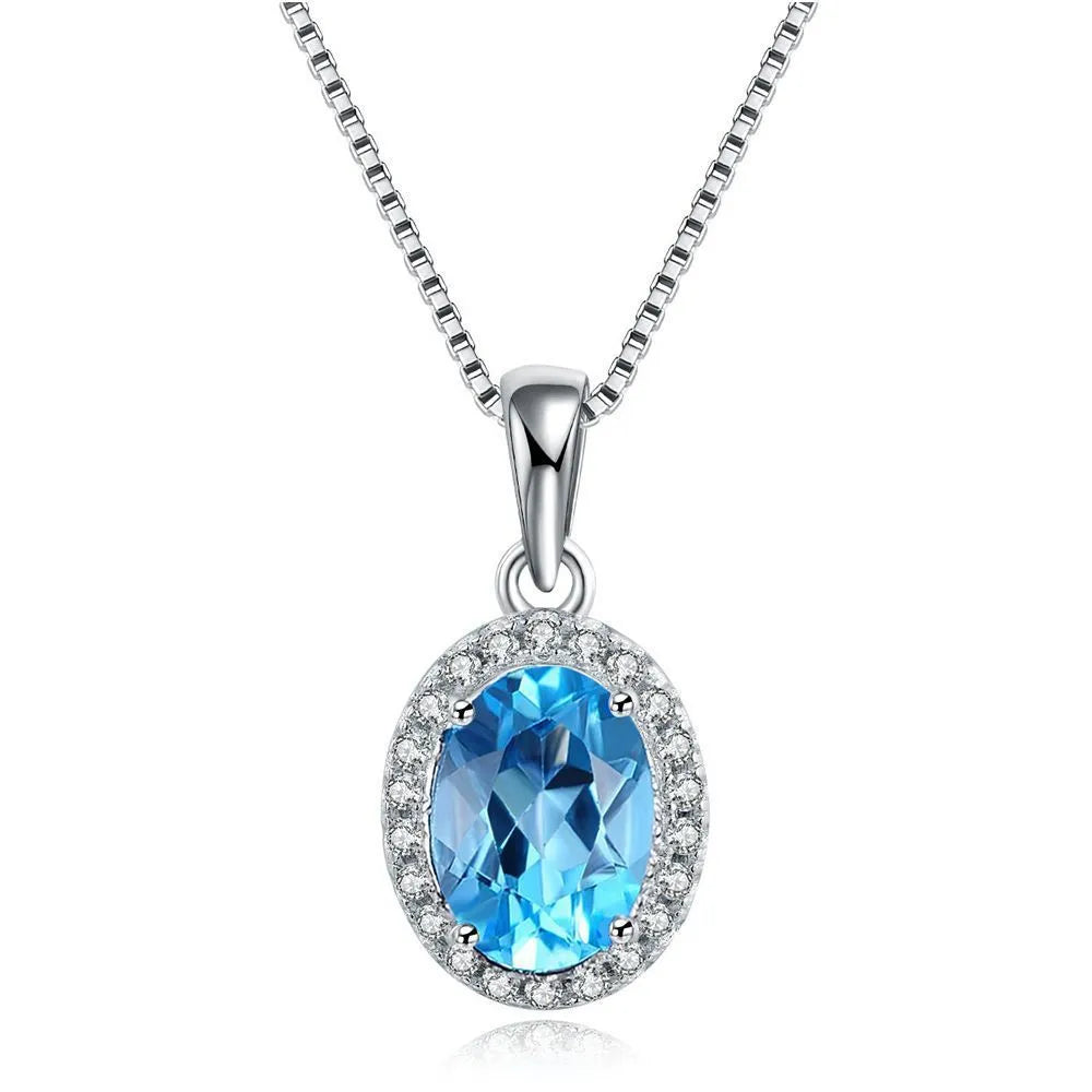 Women's four-piece sterling silver jewellery set with blue topaz gems, showing geometric earrings, ring, pendant and necklace.