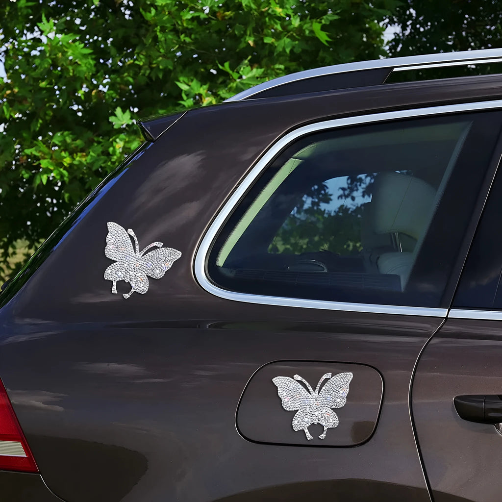 Close-up of a diamond-encrusted glass car sticker showing butterfly and bear claw design options.