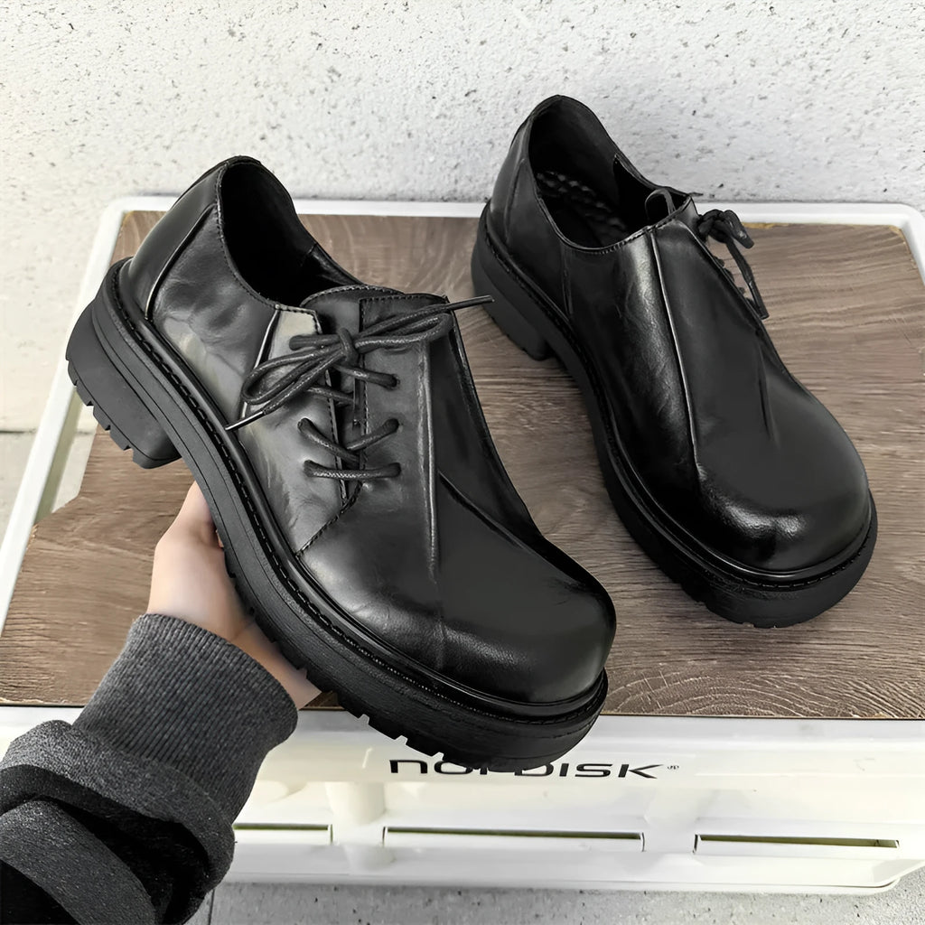 Black platform leather shoes with round toe and low top upper on a rubber sole