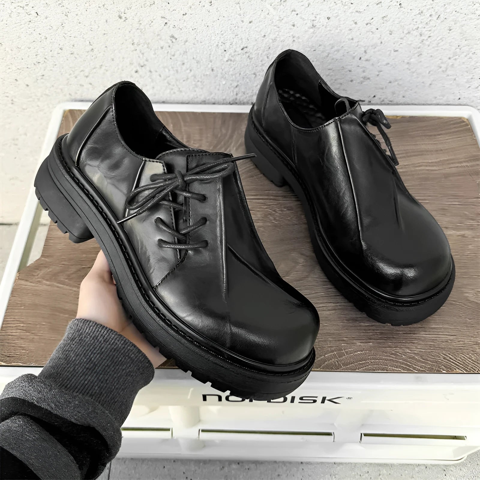 Black platform leather shoes with round toe and low top upper on a rubber sole