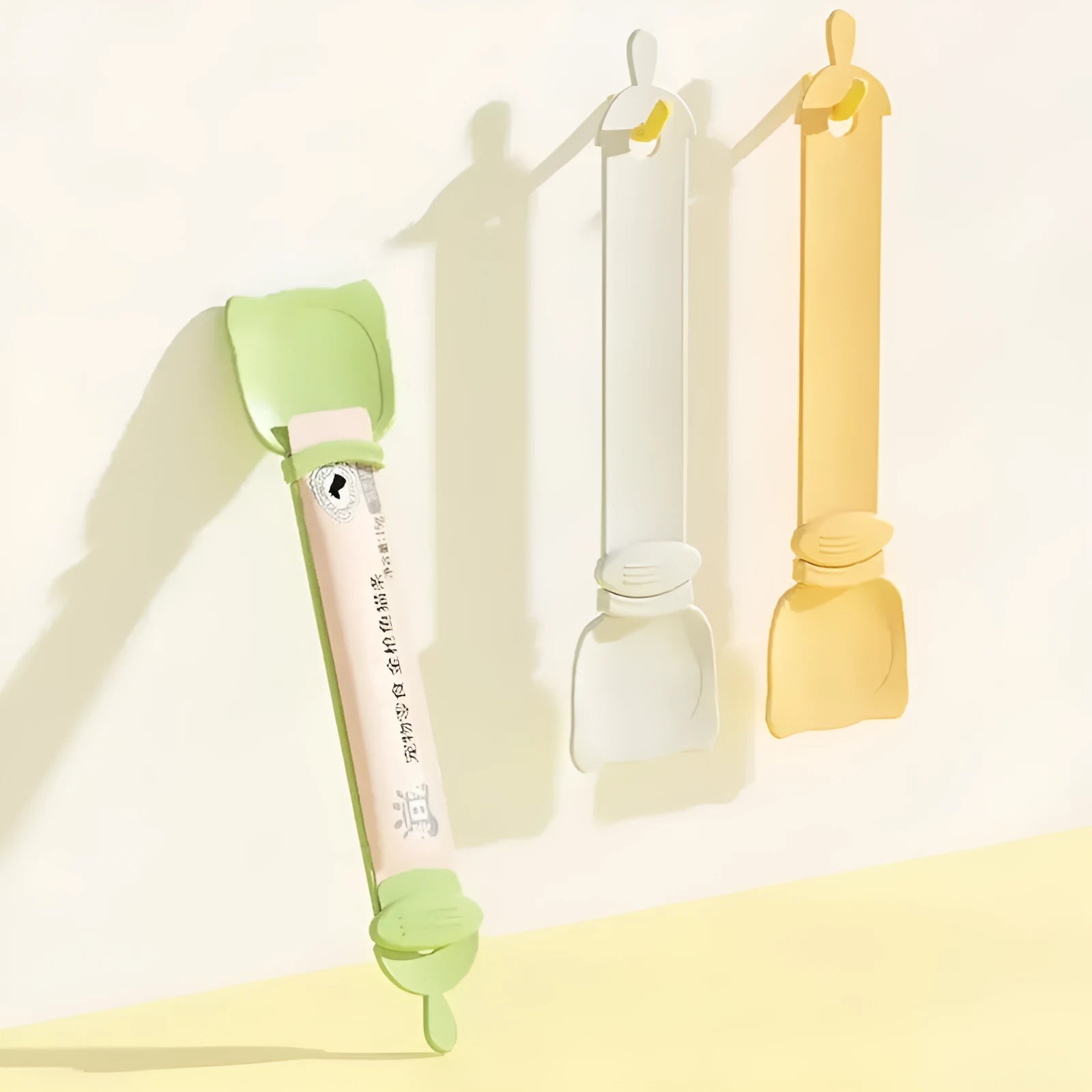 Cat Treat Spoon in green, orange, and white, measuring 27 x 6.5 cm, designed for scooping and serving cat strips