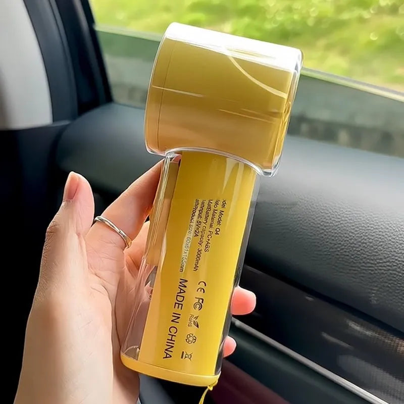 Yellow handheld fan with ice compress function showing compact size and USB port.