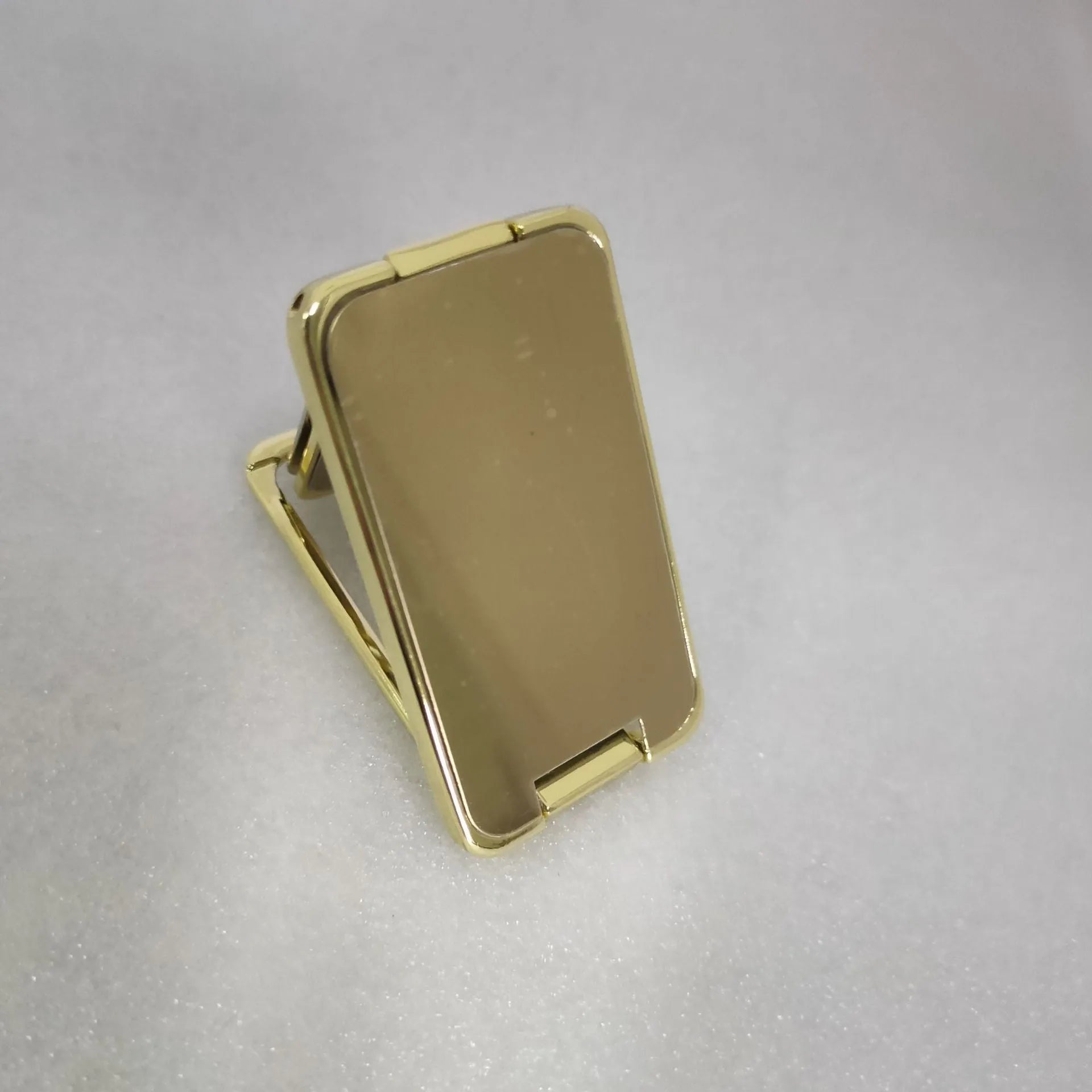 Silver foldable mobile phone holder with magnetic bracket showing adjustable viewing angles