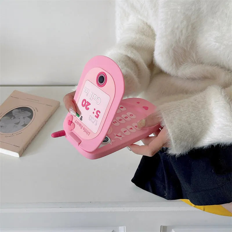 Pink silicone flip phone case for iPhone with a built-in compact mirror on the front.