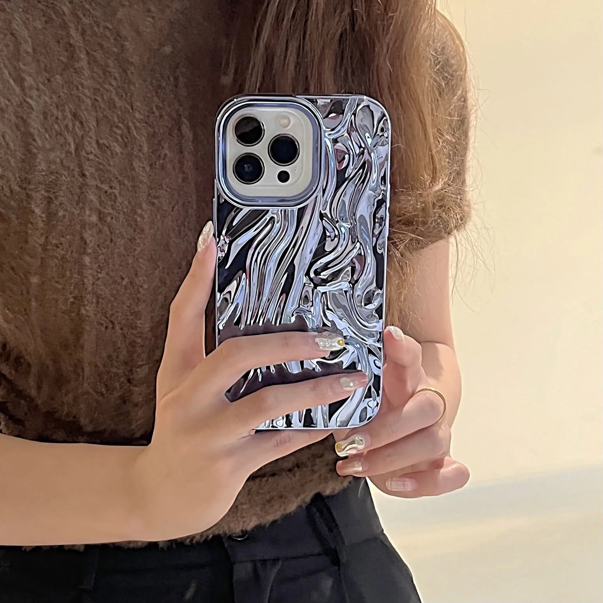 Soft TPU iPhone case with a textured three-dimensional pleated pattern in an electroplated silver finish.