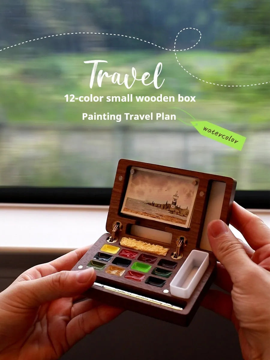 Mini walnut wood watercolour paint box open to show a set of professional paint pigments.