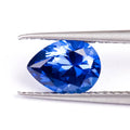Loose blue heart-shaped cultivated sapphire gemstone on a jewellery cloth.