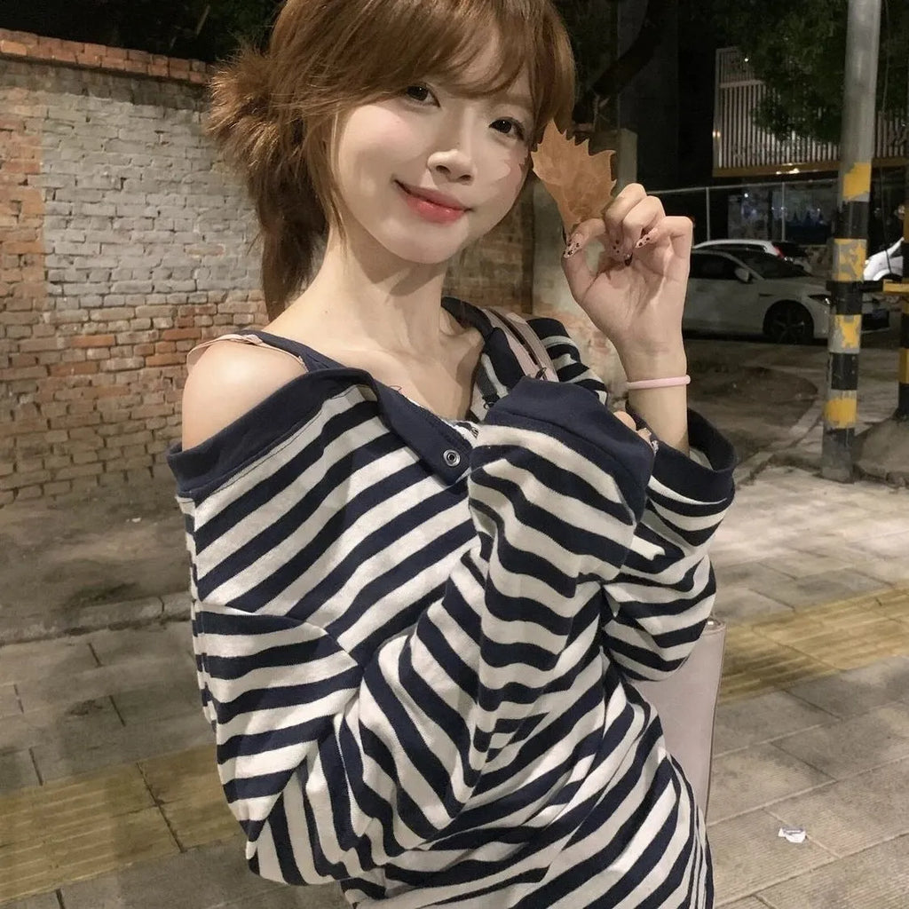 Dark blue women's oversized long-sleeved t-shirt with embroidery and stripe details on a hanger.