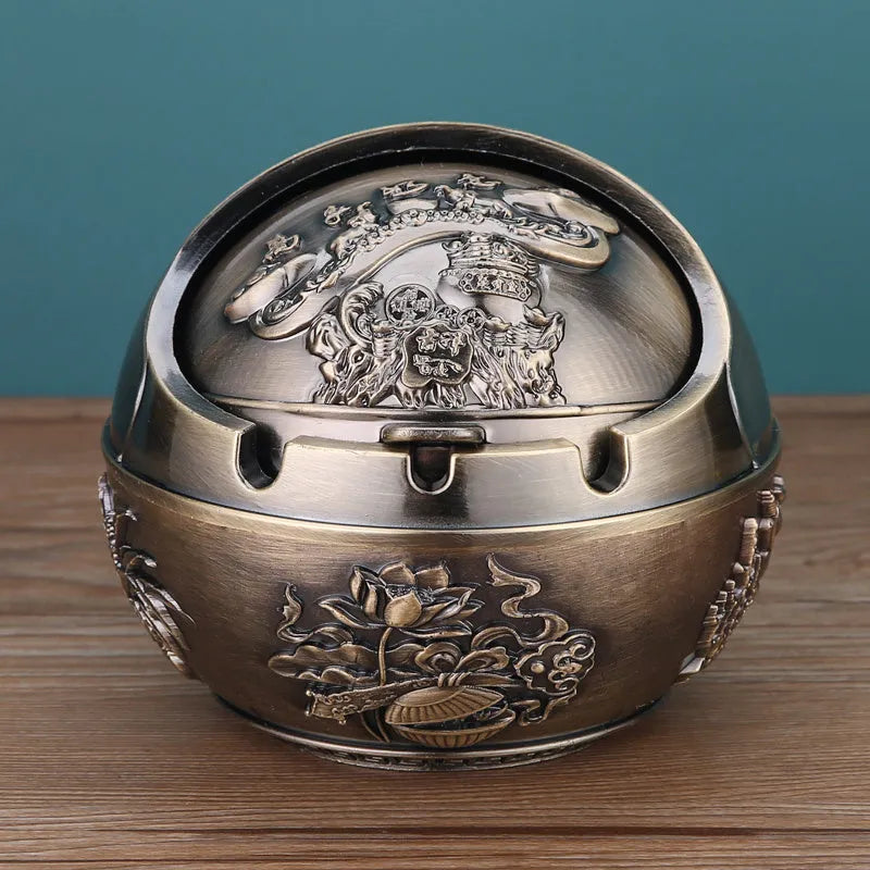 Alloy decorative ashtray in bronze with ornate peacock motif and cigarette extinguishing slot.