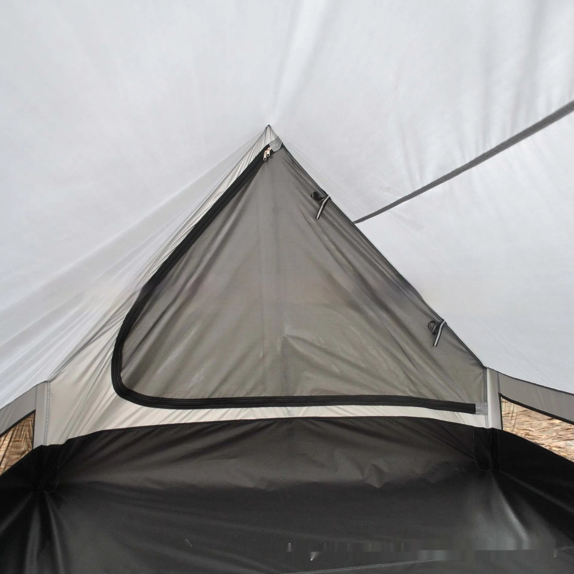 Brown A-line hiking tent pitched using trekking poles with guy ropes secured