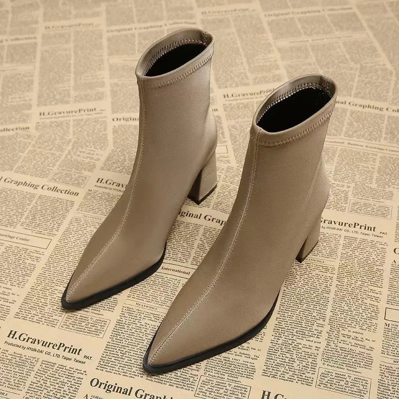 Women's khaki stretch suede pointed-toe boots with a wedge heel on a mid-calf.