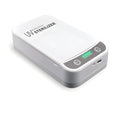 Compact white UV disinfection box with closed lid, showing scale next to a mobile phone.