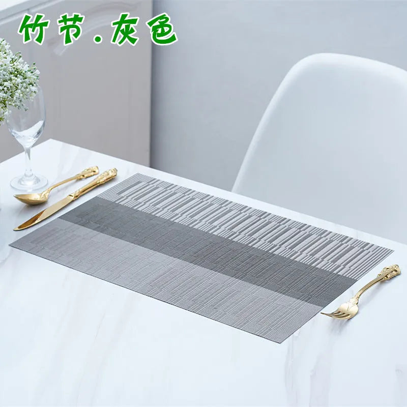 Modern PVC placemat in gradient bamboo design on a wooden dining table.