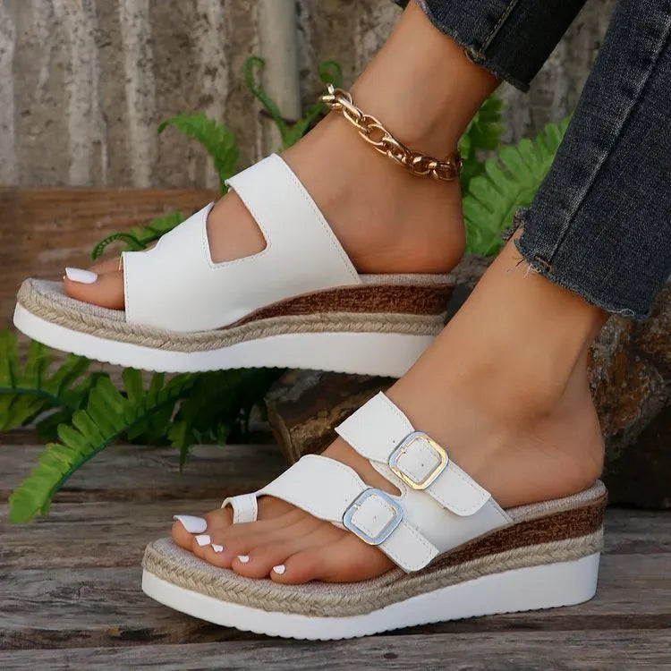 White patent leather wedge sandals with woven upper and finger fit design on a rubber sole.