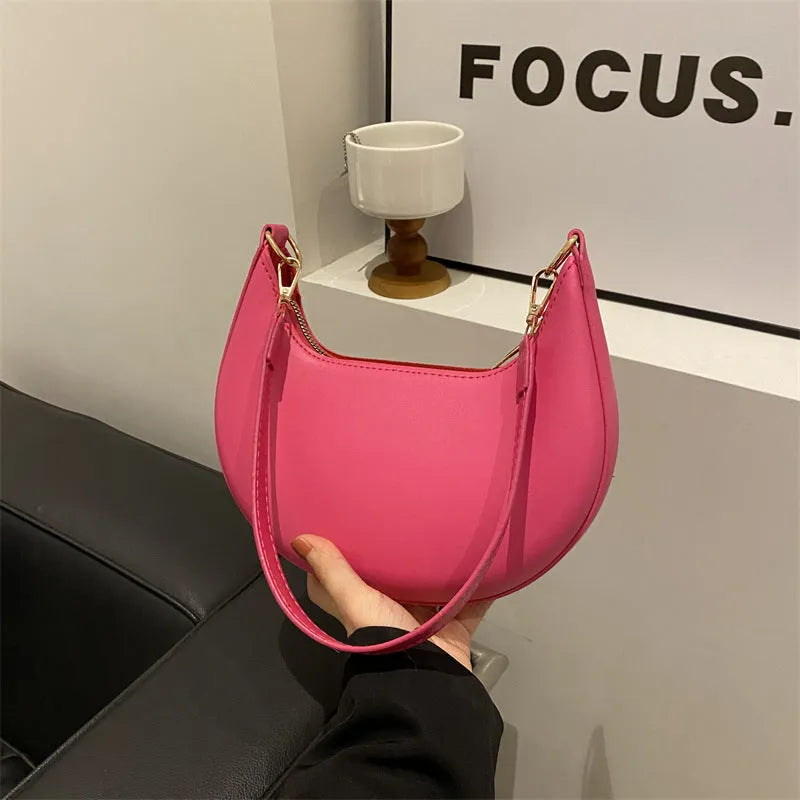 Round black women's one-shoulder underarm bag with sewing line details and a single strap.