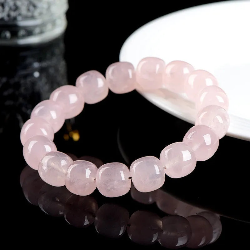 Pink crystal barrel bead bracelet with geometric design on a bamboo string.